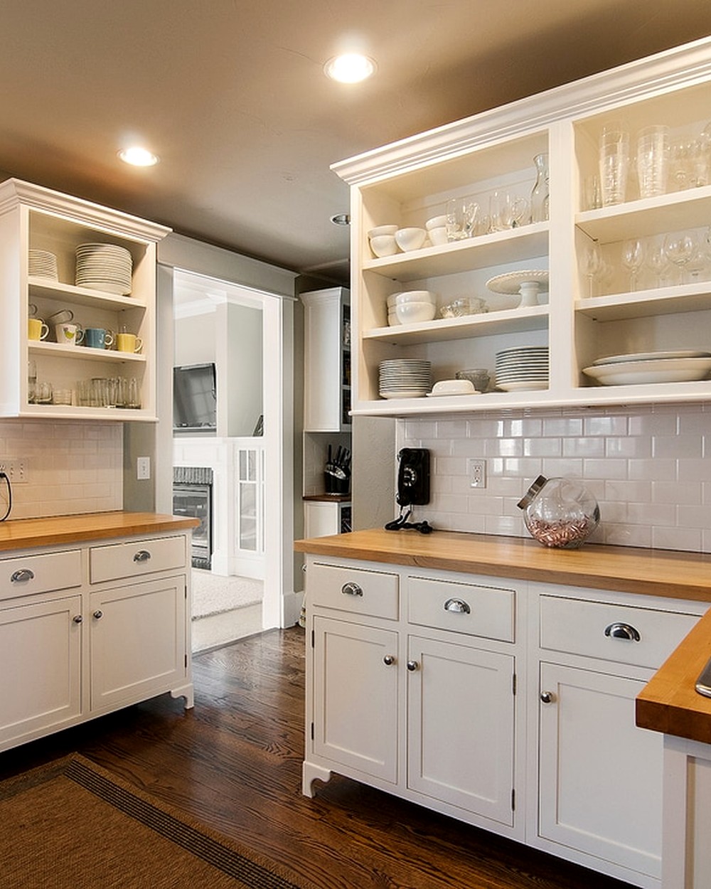Detail of white open kitchen shelving with glassware and dishware