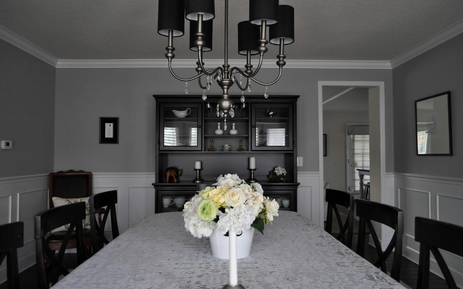 JML Interiors hero photo — a real client dining room with a crystal chandelier and a black hutch